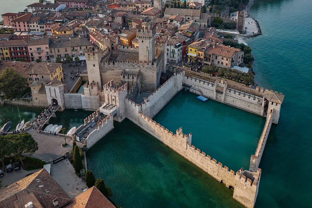 Garda Gölü kıyısında Sirmione'deki suyla çevrili Scaligero Kalesi, havadan görünüm