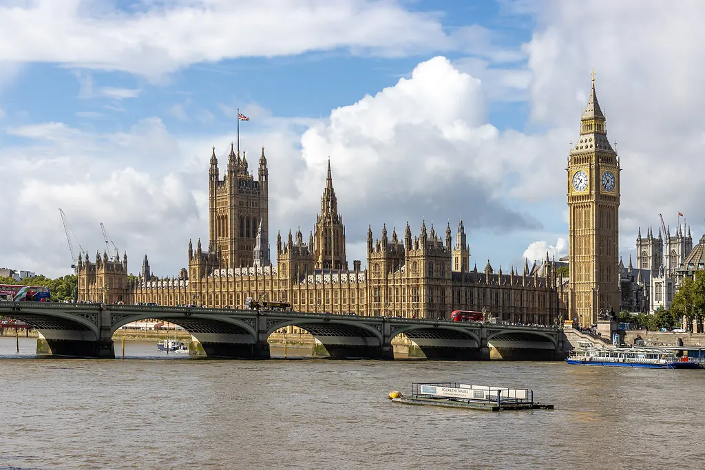 Thames Nehri'nin karşı yakasından Westminster Sarayı, Big Ben ve Westminster Köprüsü, bulutlu mavi gökyüzü altında