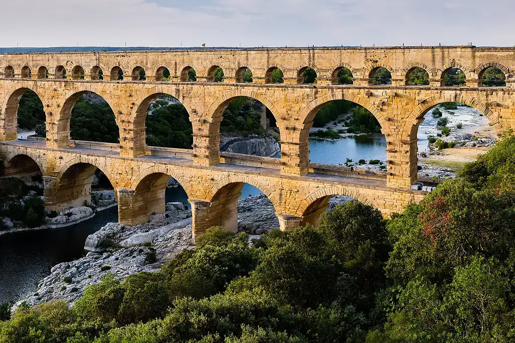 Gardon Vadisi'nde üç katlı Roma su kemeri Pont du Gard, yeşillikler arasında altın saat ışığıyla