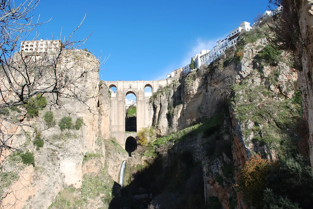 Ronda'da El Tajo vadisinin üzerinde yükselen Puente Nuevo köprüsü ve iki yanındaki kayalık yamaçlar