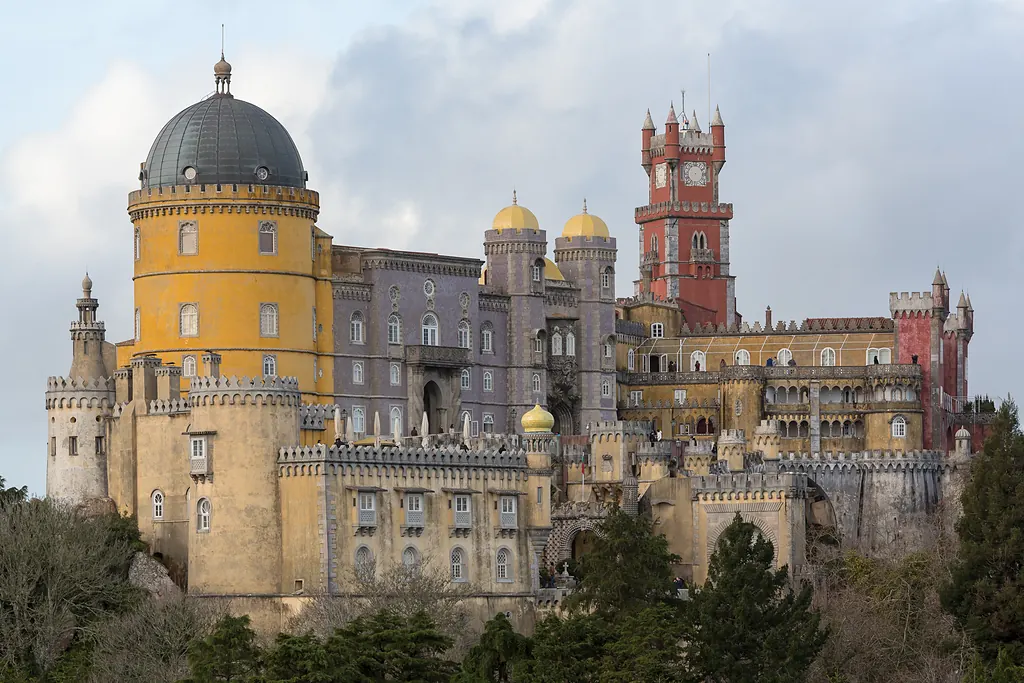 Sintra'daki Pena Sarayı'nın sarı yuvarlak kulesi, gri kubbesi ve kırmızı saat kulesi