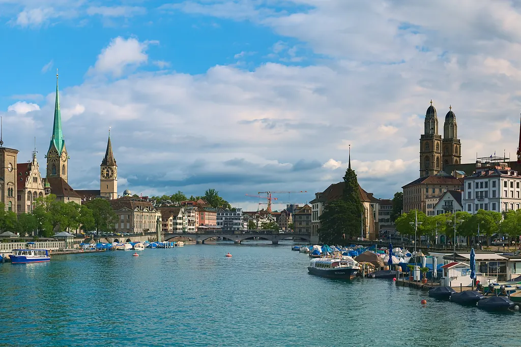 Zürih'te Limmat Nehri kıyısında Fraumünster ile Grossmünster'in kuleleri ve nehirdeki tekneler